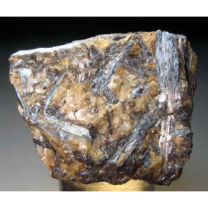 Long prismatic silvery crystals to 4.5cm in brown Siderite matrix.