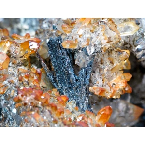 Черные кристаллы бетехтинита до 1 см, в кварце, окрашенном соединениями железа. Джезказган, Казахстан