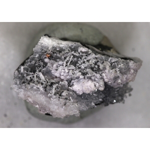 Мелкие темные кристаллы манганоквадратита на кварце