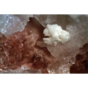 Белые кристаллы грайсита с красным виллиомитом.